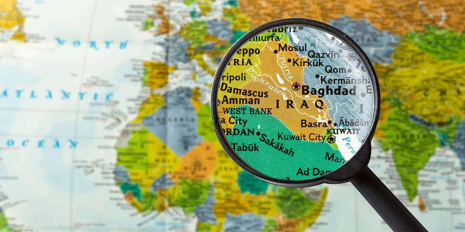 Picture of a magnifying glass held over the country of Iraq on a globe